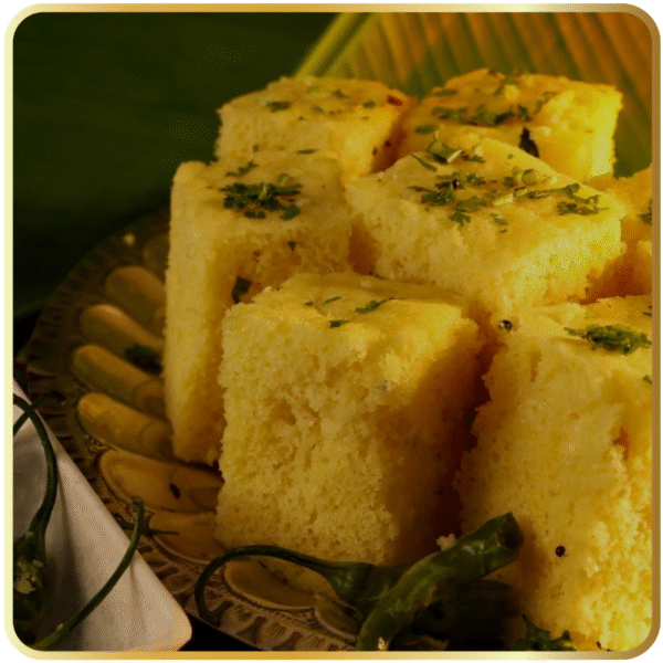 Soft and spongy dhokla garnished with mustard seeds and coriander – Gangdhar Mithaiwale